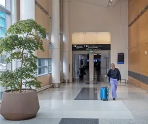 A person walking down a hallway with luggage